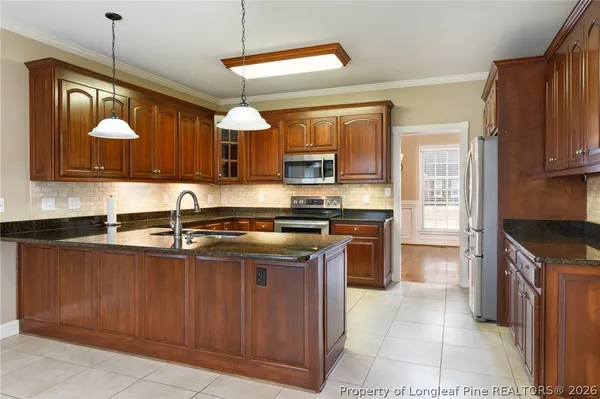 a kitchen with granite countertop a stove top oven microwave and cabinets