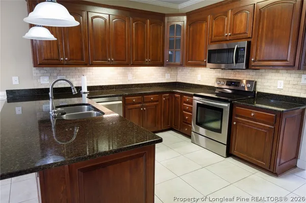 a kitchen with granite countertop stainless steel appliances and wooden cabinets