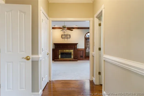 a view of a livingroom with a fireplace a chandelier a wooden table and chair