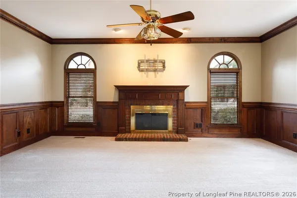 a view of an empty room with a fireplace and a window