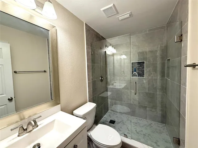 a bathroom with a sink a toilet and shower
