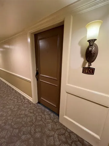 a view of an empty room with wooden floor and stairs