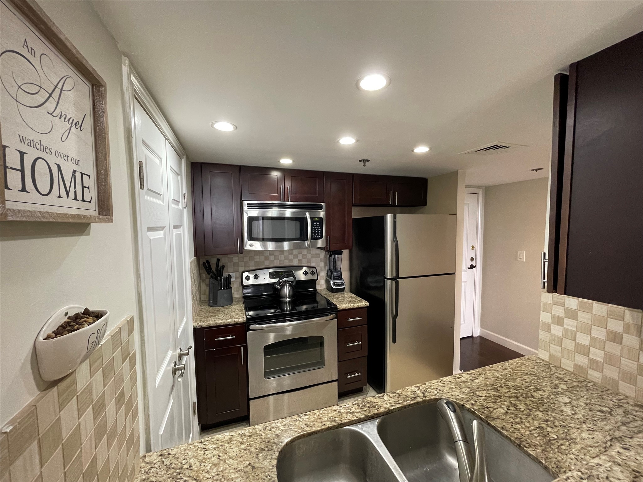 3525 Sage Road, Unit 1401 Houston, TX 77056 - Photo 15 of 22 a kitchen with stainless steel appliances kitchen island granite countertop a refrigerator stove and oven