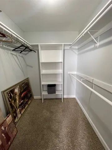 a bedroom with a bed and a flat tv screen on the dresser