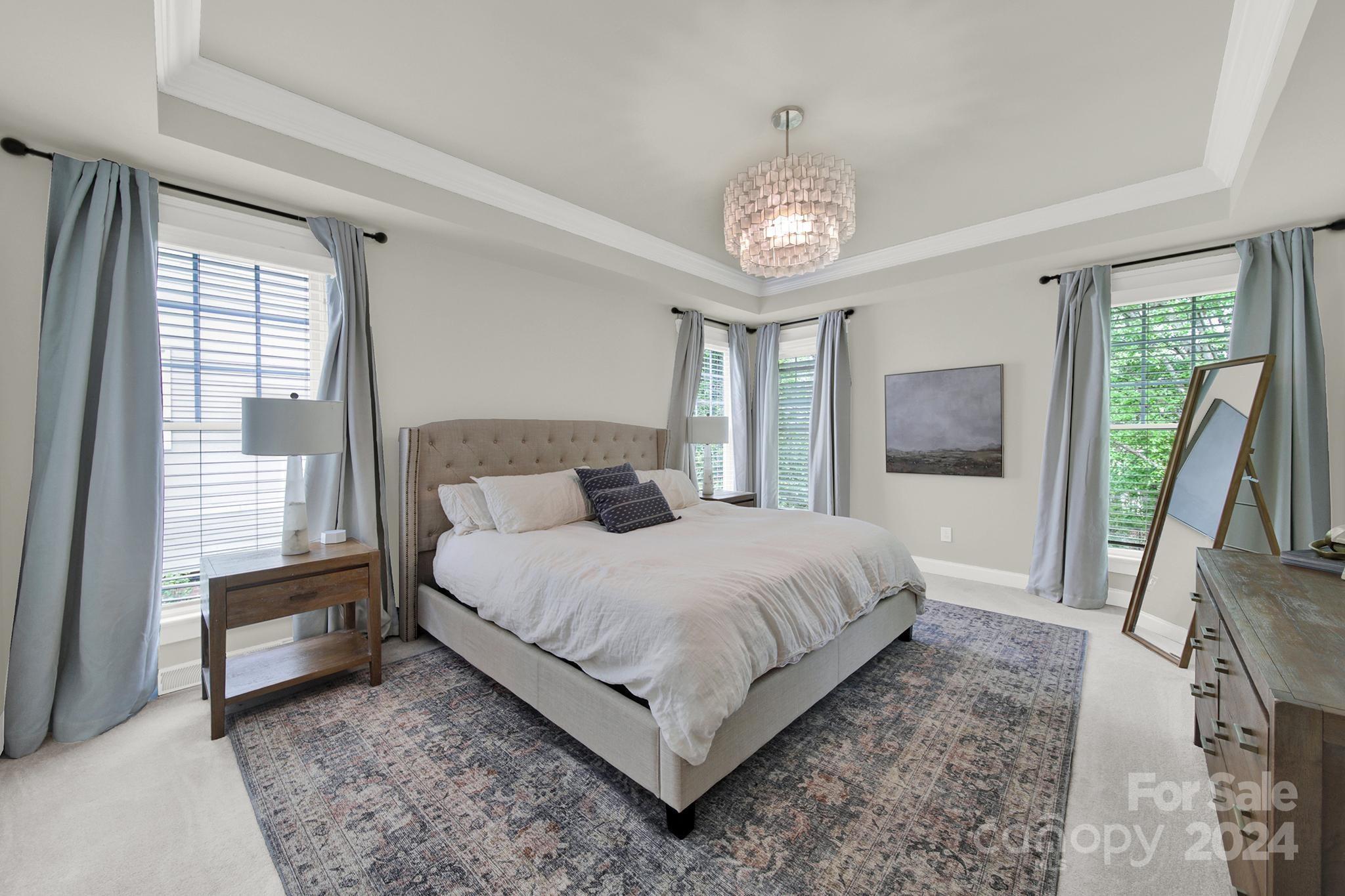 130 Mills Lane Fort Mill, SC 29708 - Photo 22 of 48 a bedroom with a large bed and a chandelier