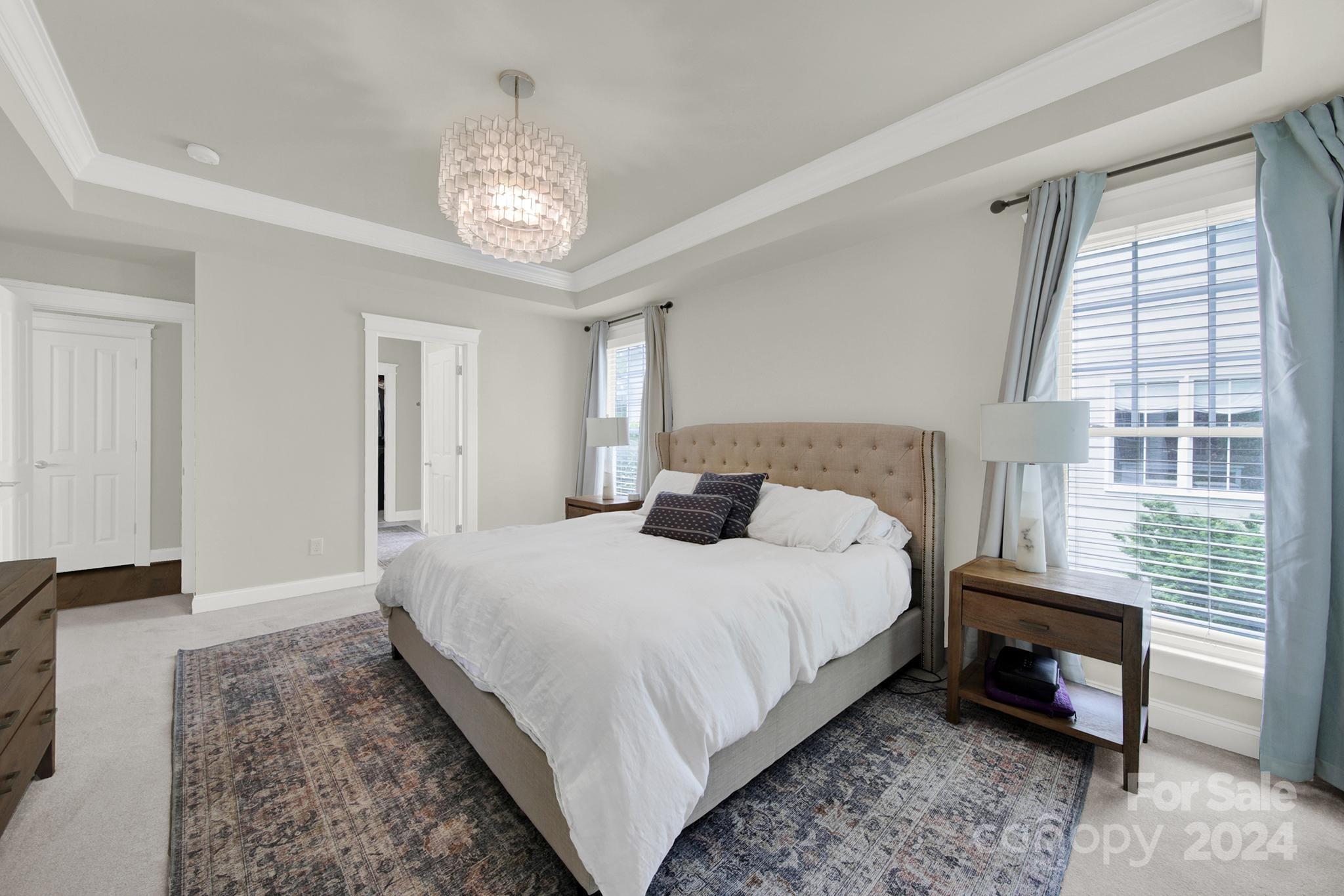 130 Mills Lane Fort Mill, SC 29708 - Photo 24 of 48 a spacious bedroom with a bed a chandelier and a window