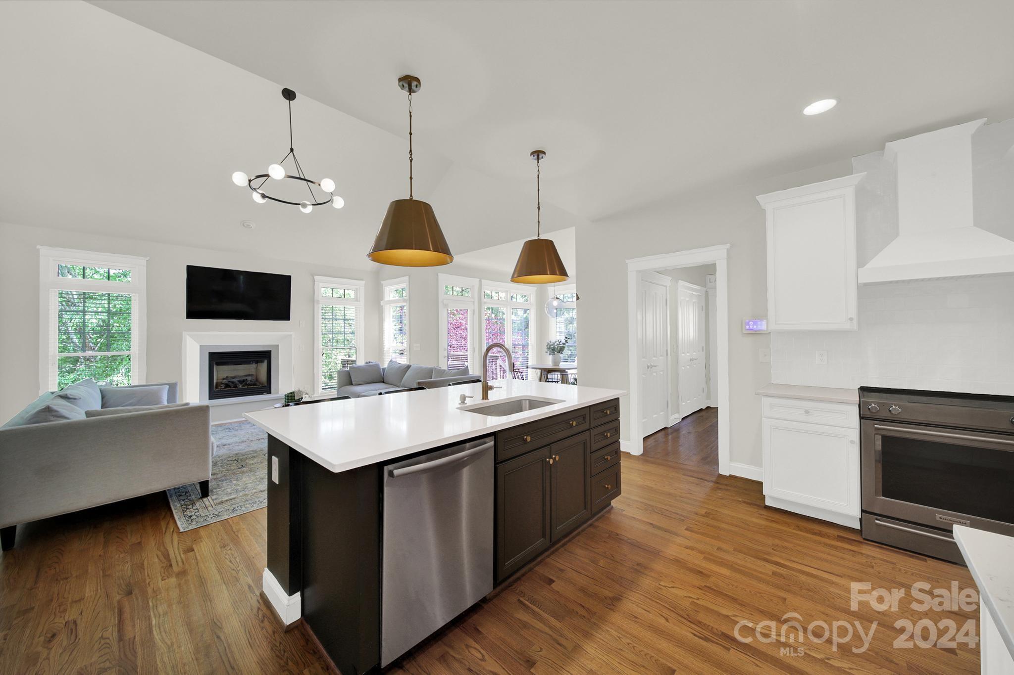 130 Mills Lane Fort Mill, SC 29708 - Photo 9 of 48 a kitchen with stainless steel appliances granite countertop a sink a stove and a wooden floors