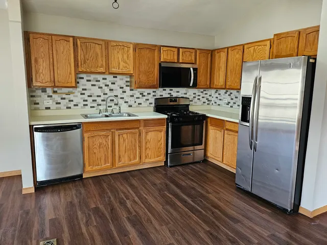 a view of a kitchen with a stove wooden floor and a chandelier