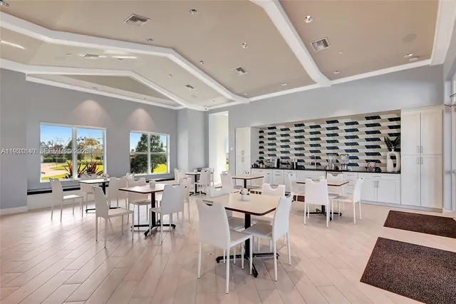 a living room with chairs and tables with wooden floor