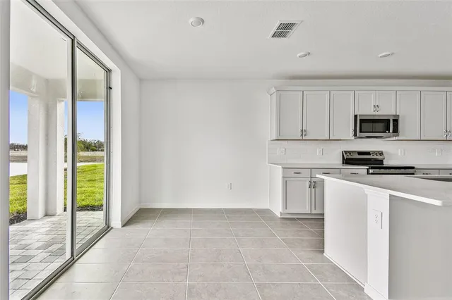 a kitchen with a refrigerator a stove top oven a sink and a window