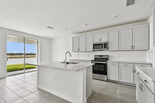 a kitchen with stainless steel appliances granite countertop a sink and a stove