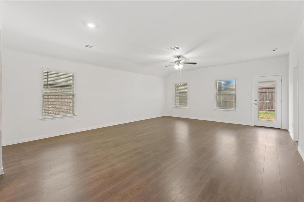 605 Spur Ridge Princeton, TX 75407 - Photo 10 of 30 a view of an empty room with wooden floor and a window