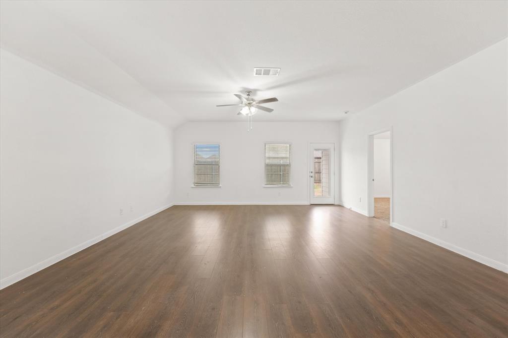 605 Spur Ridge Princeton, TX 75407 - Photo 11 of 30 an empty room with wooden floor and windows