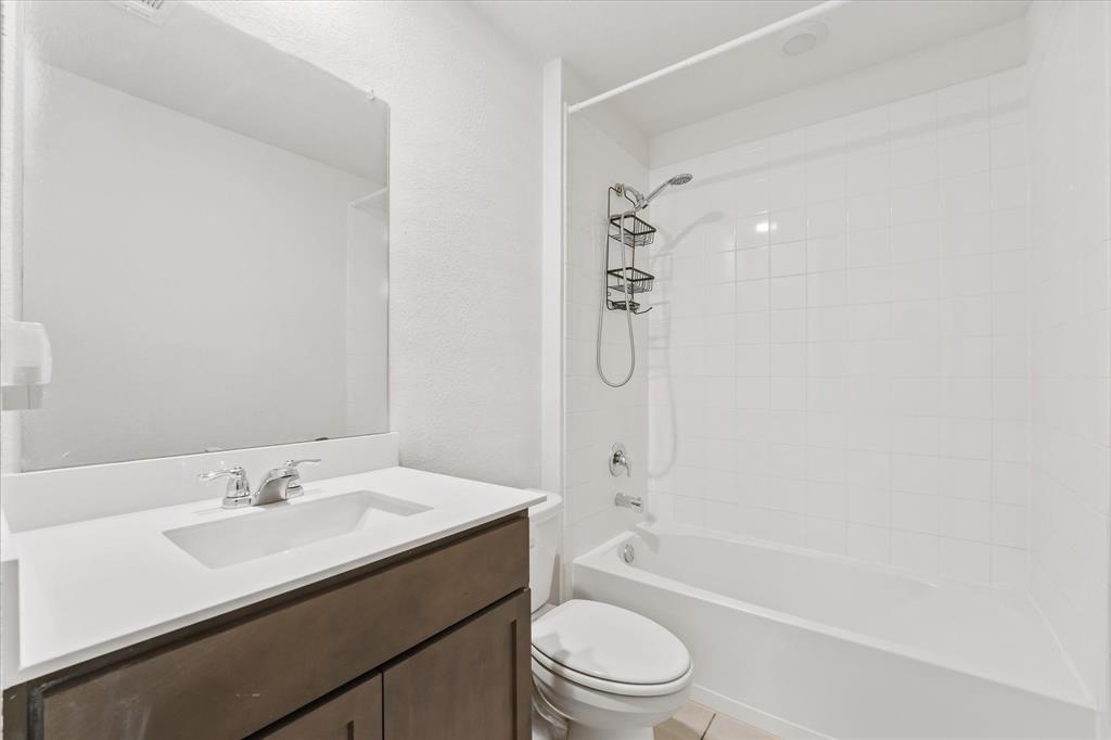 605 Spur Ridge Princeton, TX 75407 - Photo 19 of 30 a bathroom with a granite countertop sink a toilet and shower