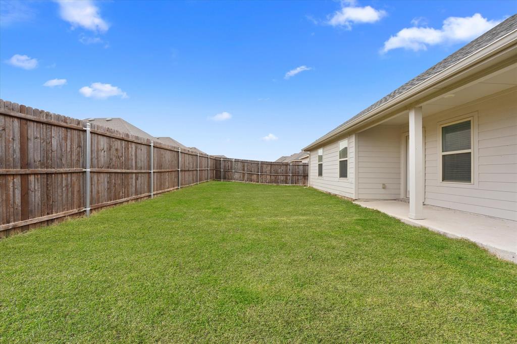 605 Spur Ridge Princeton, TX 75407 - Photo 26 of 30 a view of a backyard with plants and wooden fence