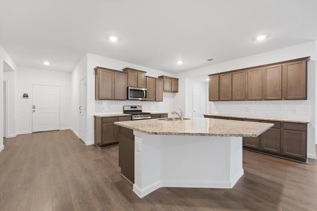 605 Spur Ridge Princeton, TX 75407 - Photo 5 of 30 a kitchen with stainless steel appliances granite countertop a stove a sink and a refrigerator