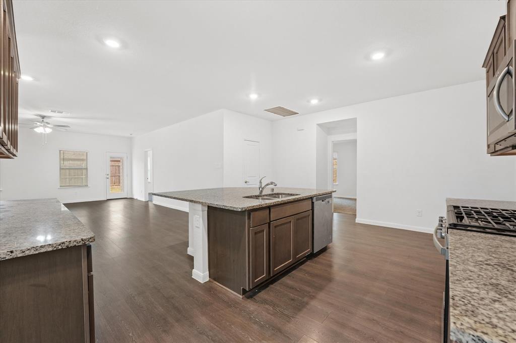 605 Spur Ridge Princeton, TX 75407 - Photo 29 of 30 a kitchen with stainless steel appliances granite countertop a stove and a sink