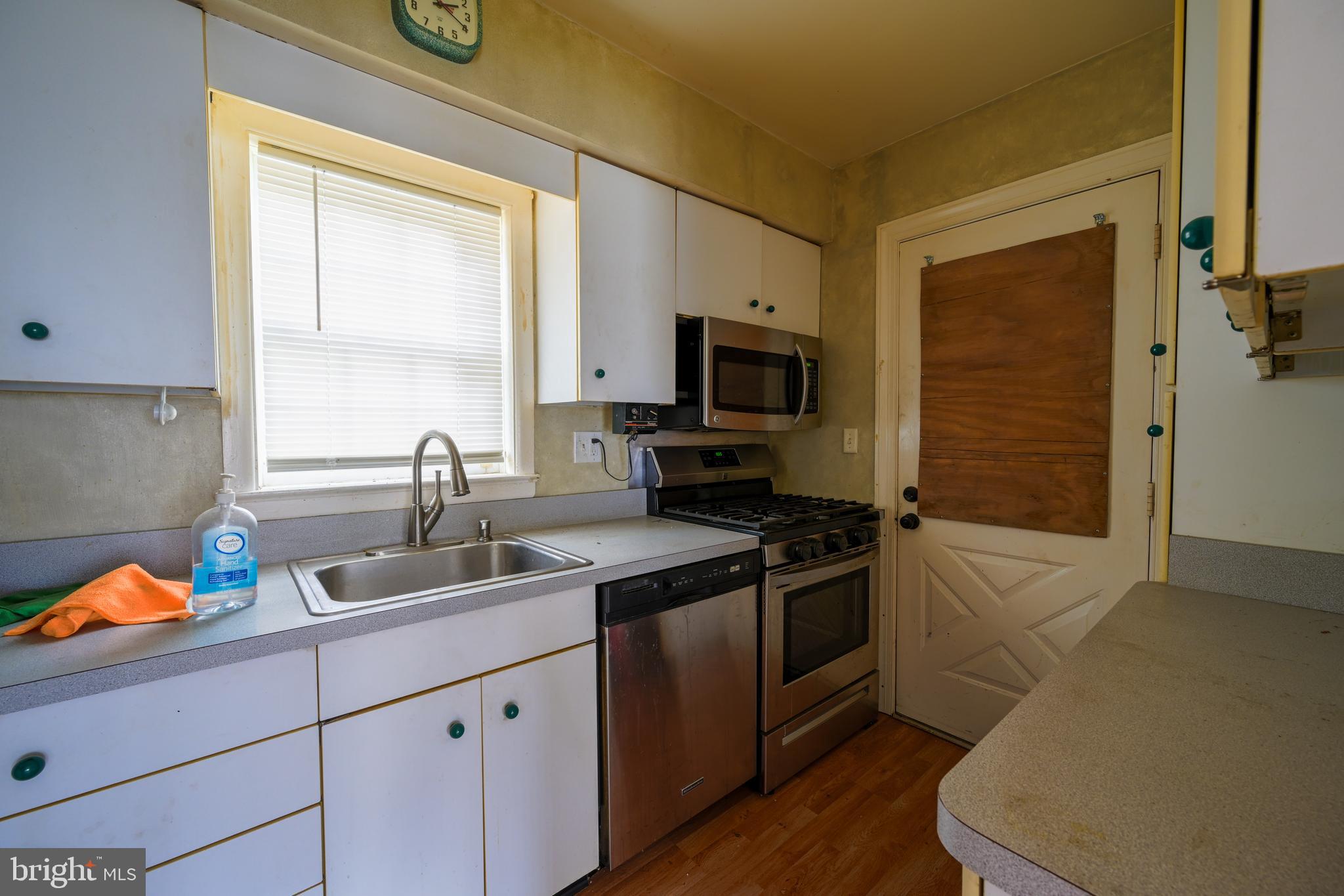 1518 Gridley Lane Silver Spring, MD 20902 - Photo 3 of 7 a kitchen with a sink stove and cabinets
