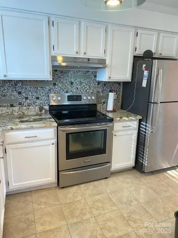 a kitchen with a stove top oven cabinets and stainless steel appliances