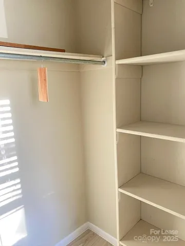 a view of walk in closet with empty racks