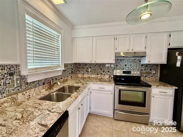 a kitchen with granite countertop a sink stainless steel appliances and cabinets