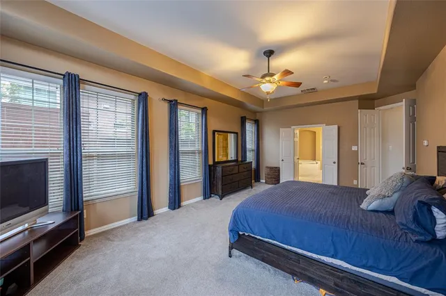 a spacious bedroom with a bed and a chandelier