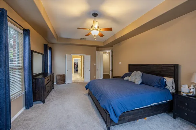 a bedroom with a large bed a flat tv screen and dresser