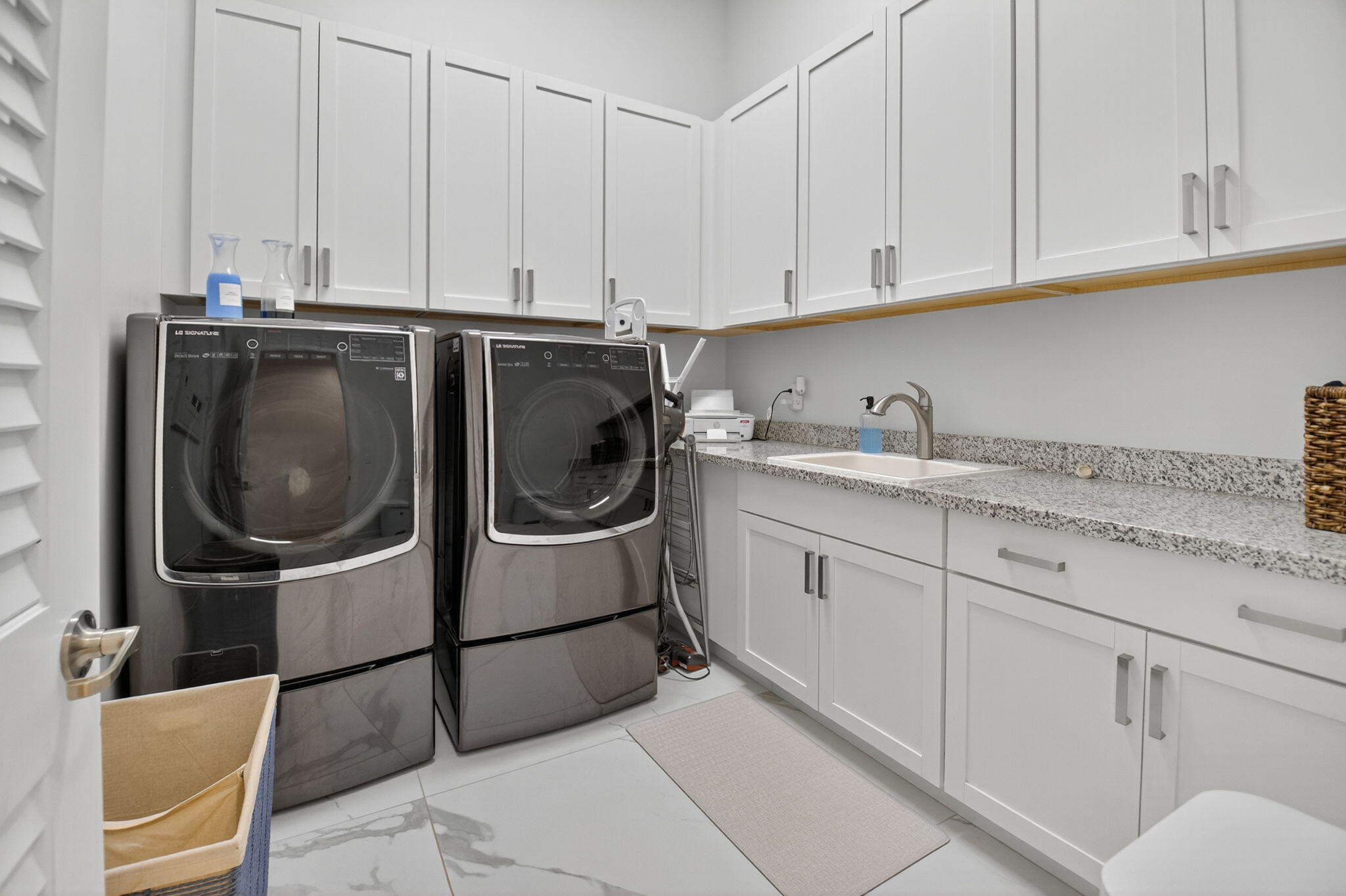 9331 Grand Prix Lane Boynton Beach, FL 33472 - Photo 42 of 96 a utility room with stainless steel appliances granite countertop a sink a washer and cabinets