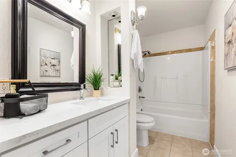 a bathroom with a granite countertop sink a toilet and shower