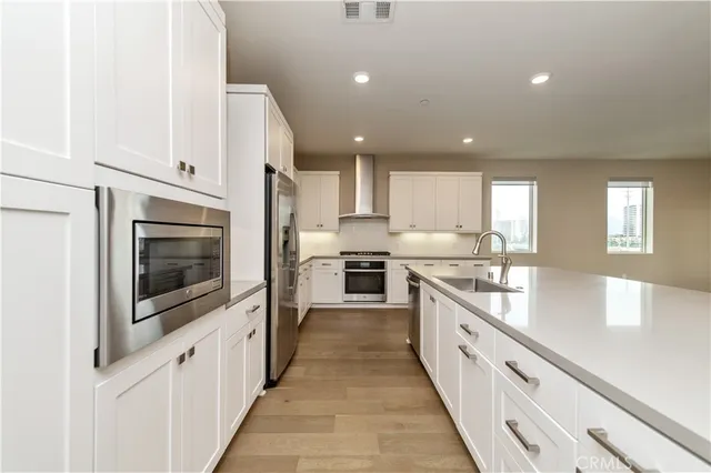 a large kitchen with stainless steel appliances kitchen island granite countertop a large counter top a stove and a sink