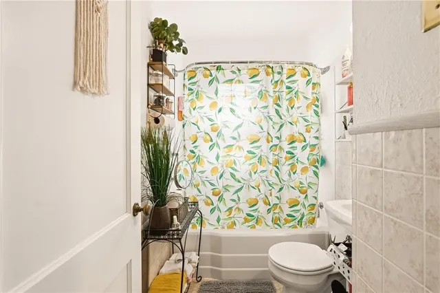 a white toilet sitting next to a shower curtain