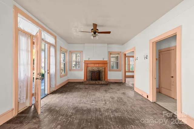 a view of a livingroom with a fireplace and ceiling fan