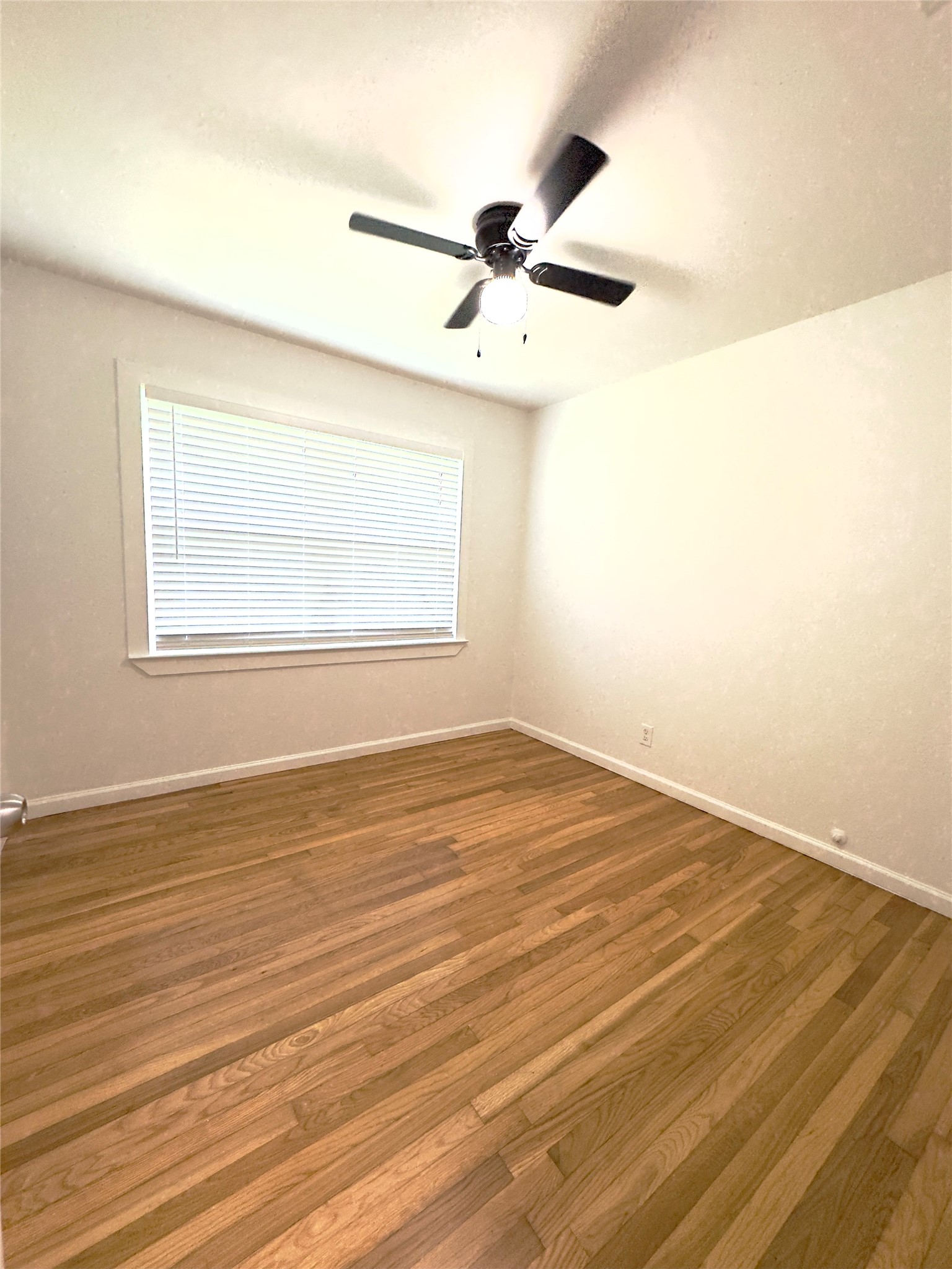 8733 Lugary Drive Houston, TX 77074 - Photo 15 of 30 an empty room with wooden floor fan and windows