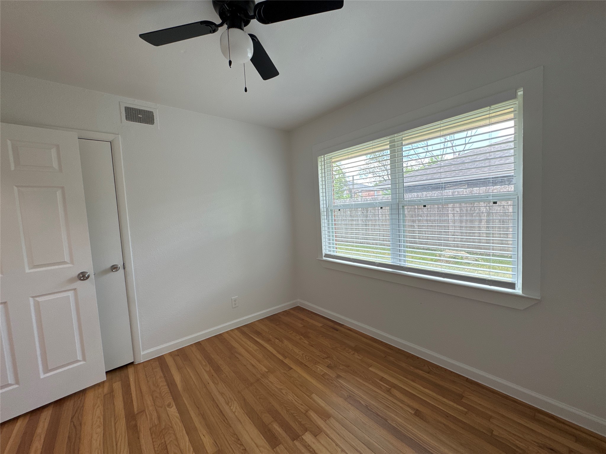 8733 Lugary Drive Houston, TX 77074 - Photo 27 of 30 a view of empty room with wooden floor and fan