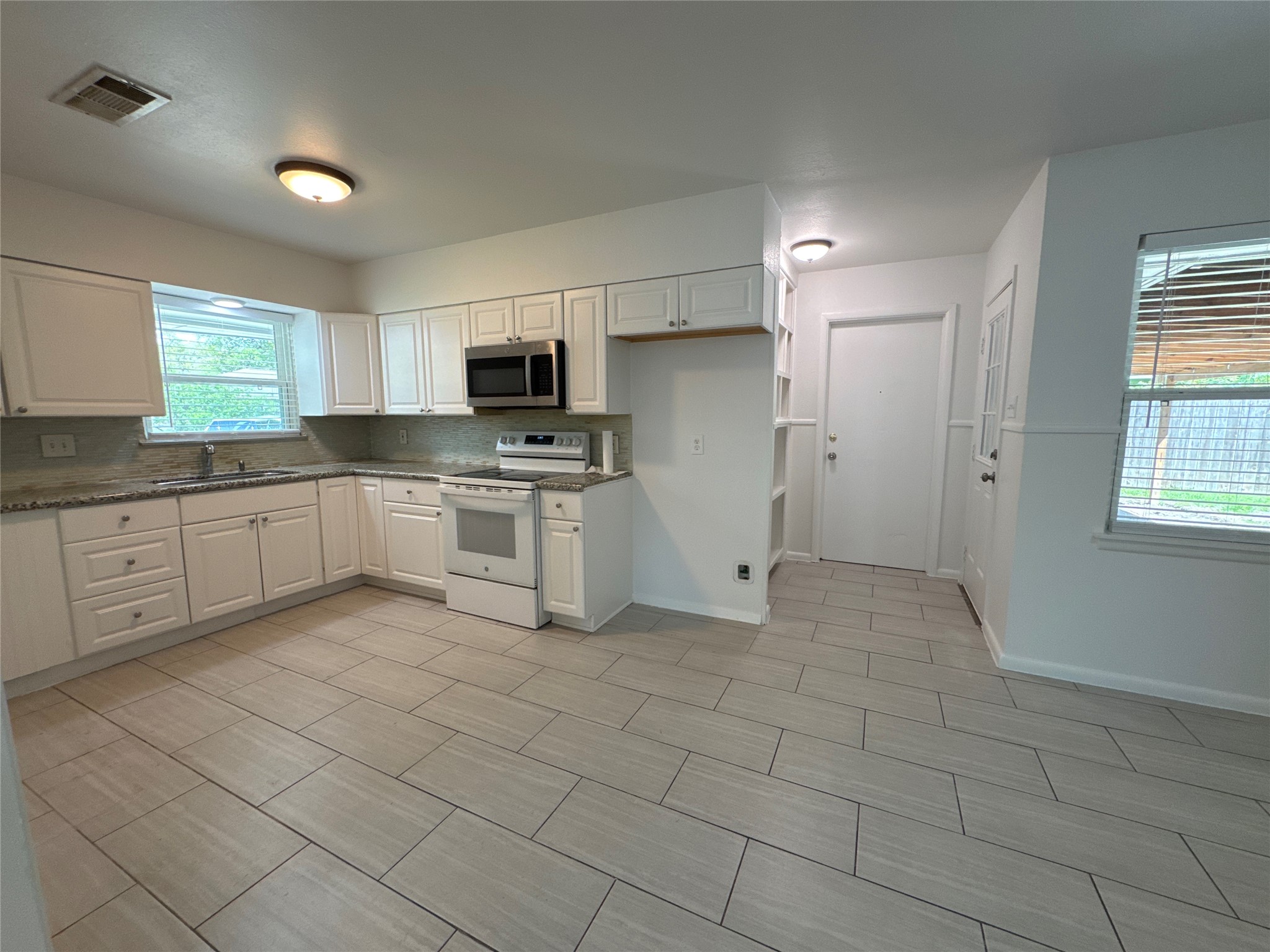 8733 Lugary Drive Houston, TX 77074 - Photo 6 of 30 a kitchen with white cabinets a sink and appliances