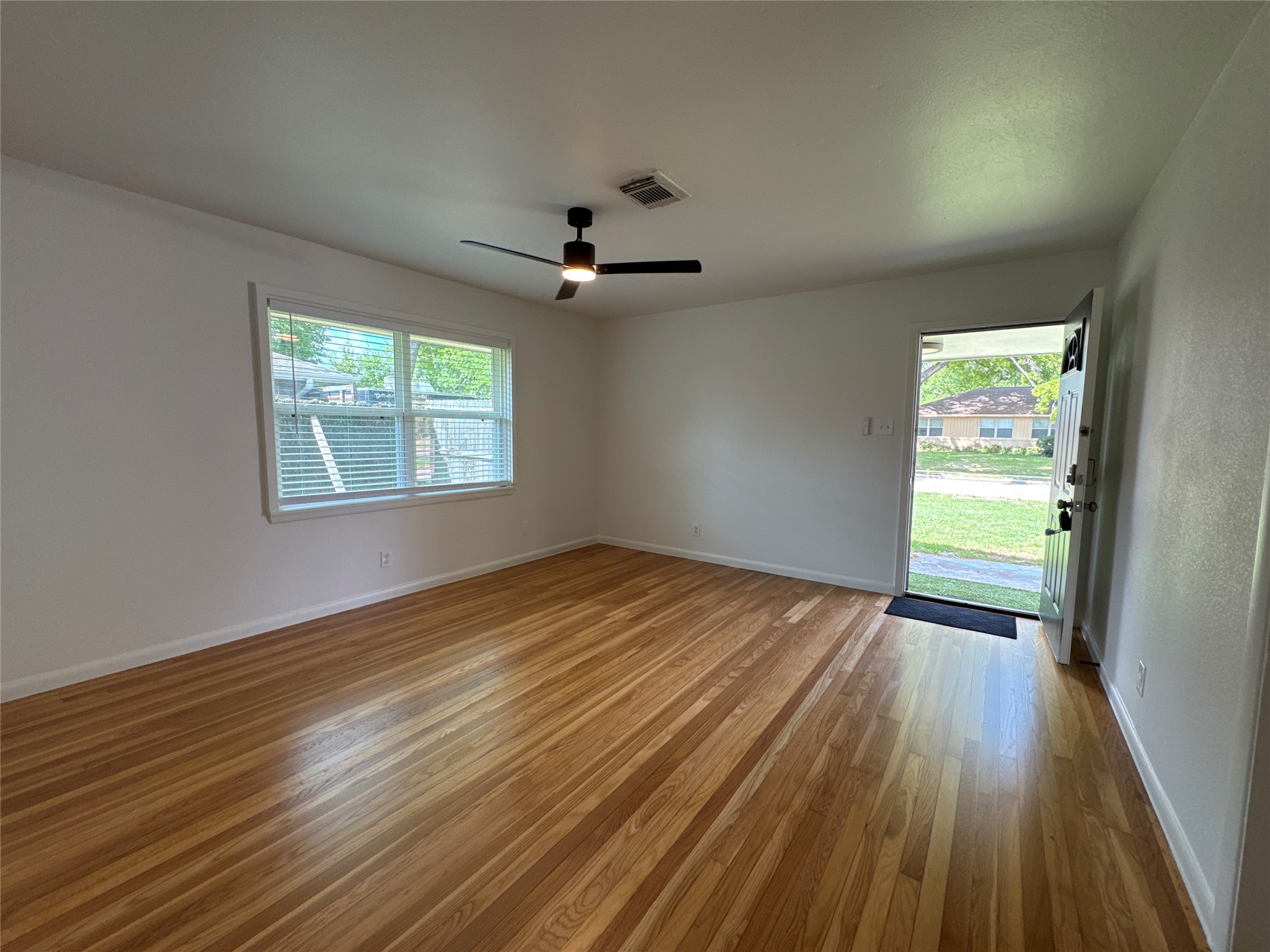 8733 Lugary Drive Houston, TX 77074 - Photo 7 of 30 a view of empty room with wooden floor and fan