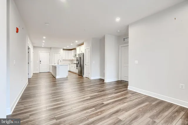a view of an empty room with wooden floor
