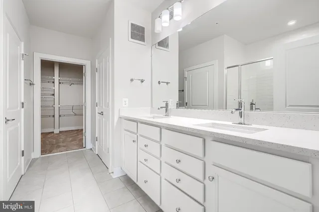 a spacious bathroom with double sink and a mirror
