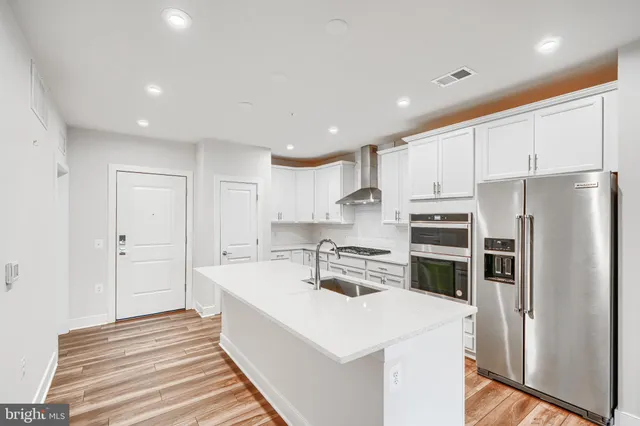 a kitchen with stainless steel appliances a refrigerator sink and cabinets