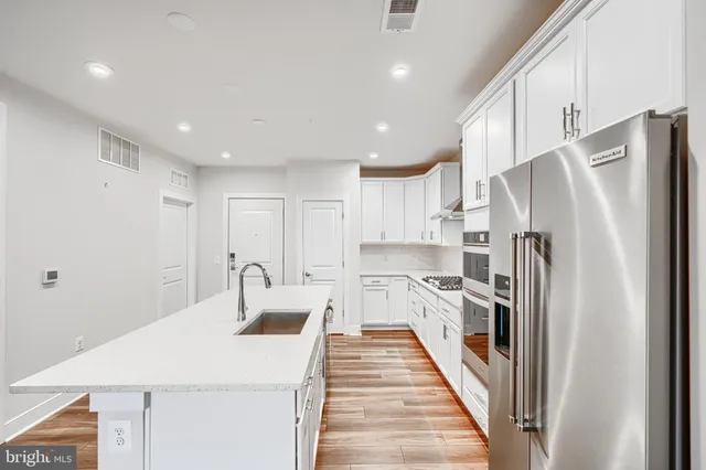 a kitchen with white cabinets and stainless steel appliances