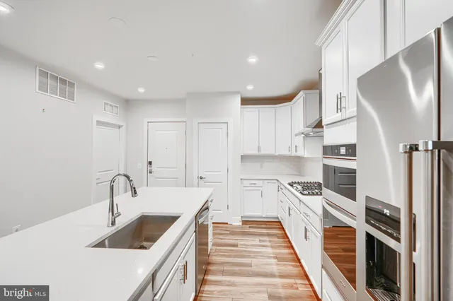 a kitchen with stainless steel appliances a sink and a stove