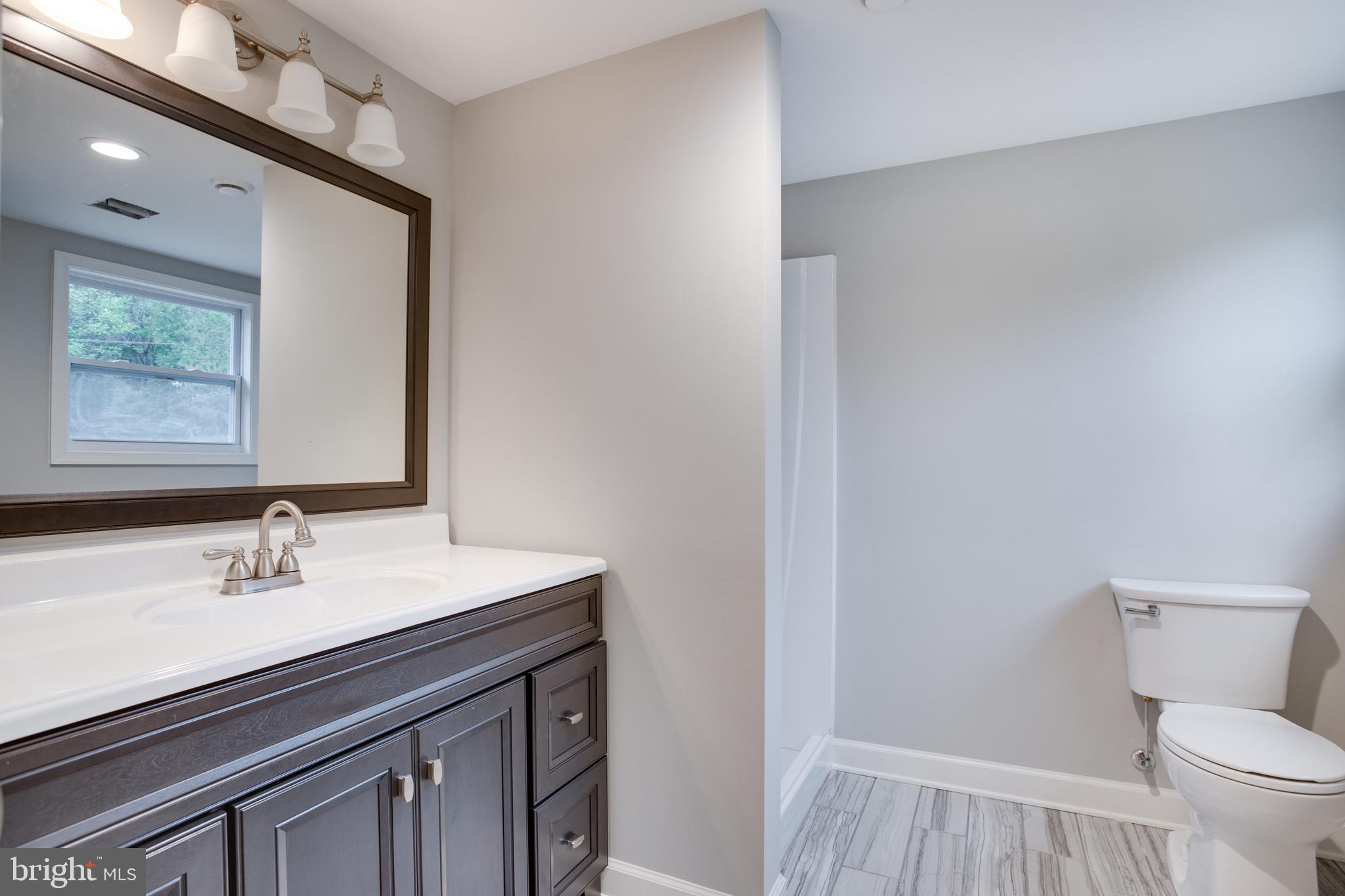 5601 Cherry Hill Road Huntingtown, MD 20639 - Photo 16 of 37 a bathroom with a sink a toilet and mirror