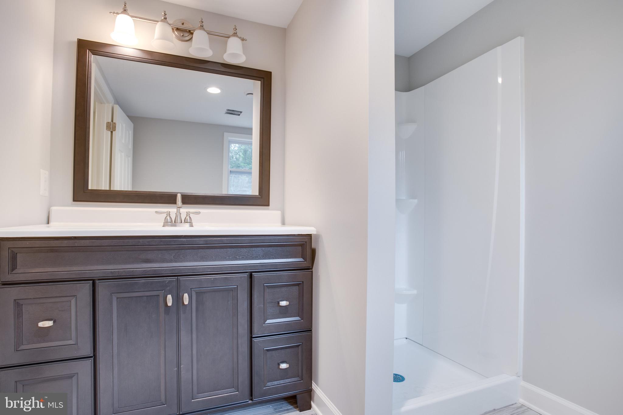 5601 Cherry Hill Road Huntingtown, MD 20639 - Photo 17 of 37 a bathroom with a sink and a mirror