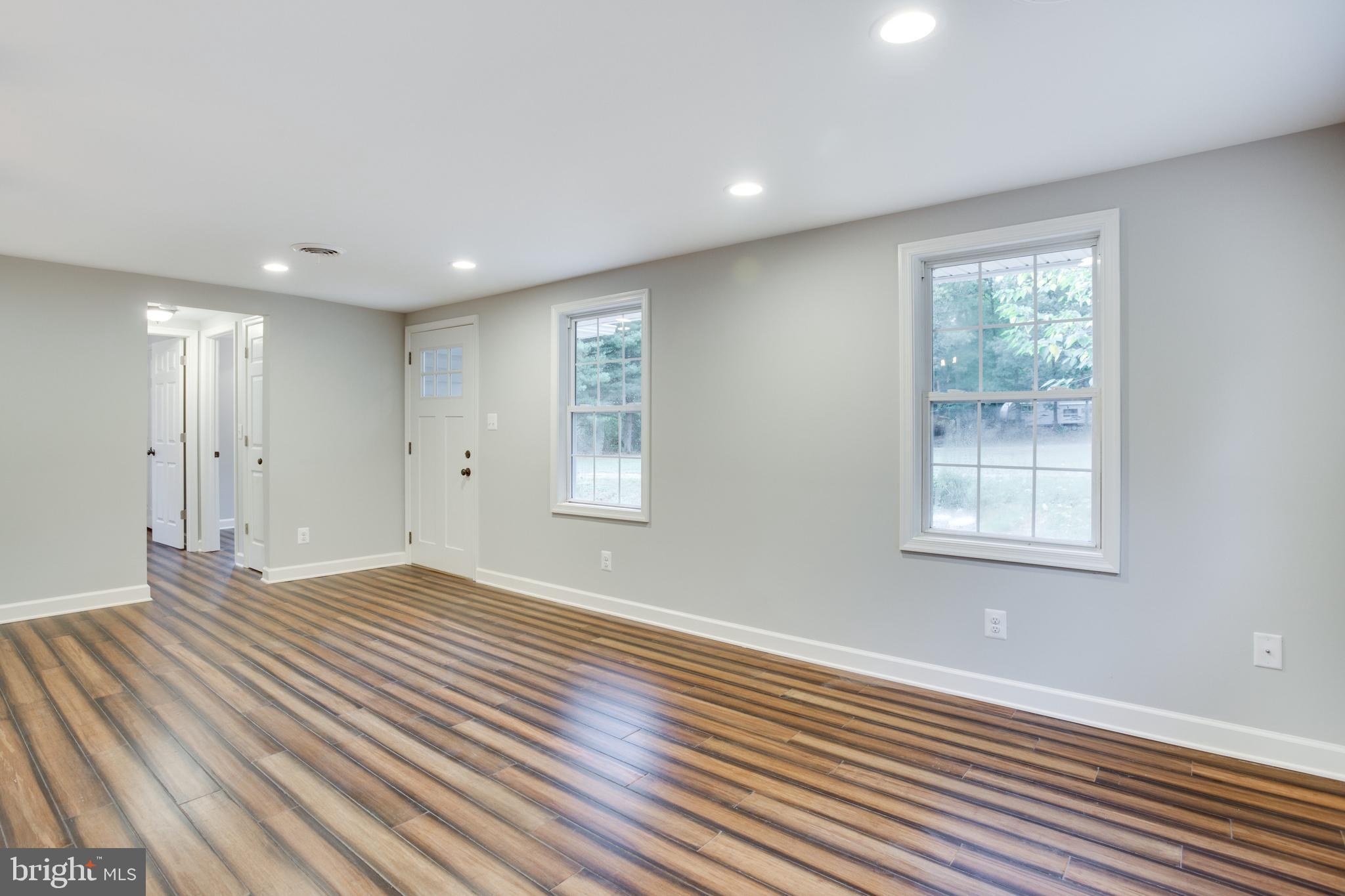 5601 Cherry Hill Road Huntingtown, MD 20639 - Photo 2 of 37 a view of an empty room with wooden floor and a window