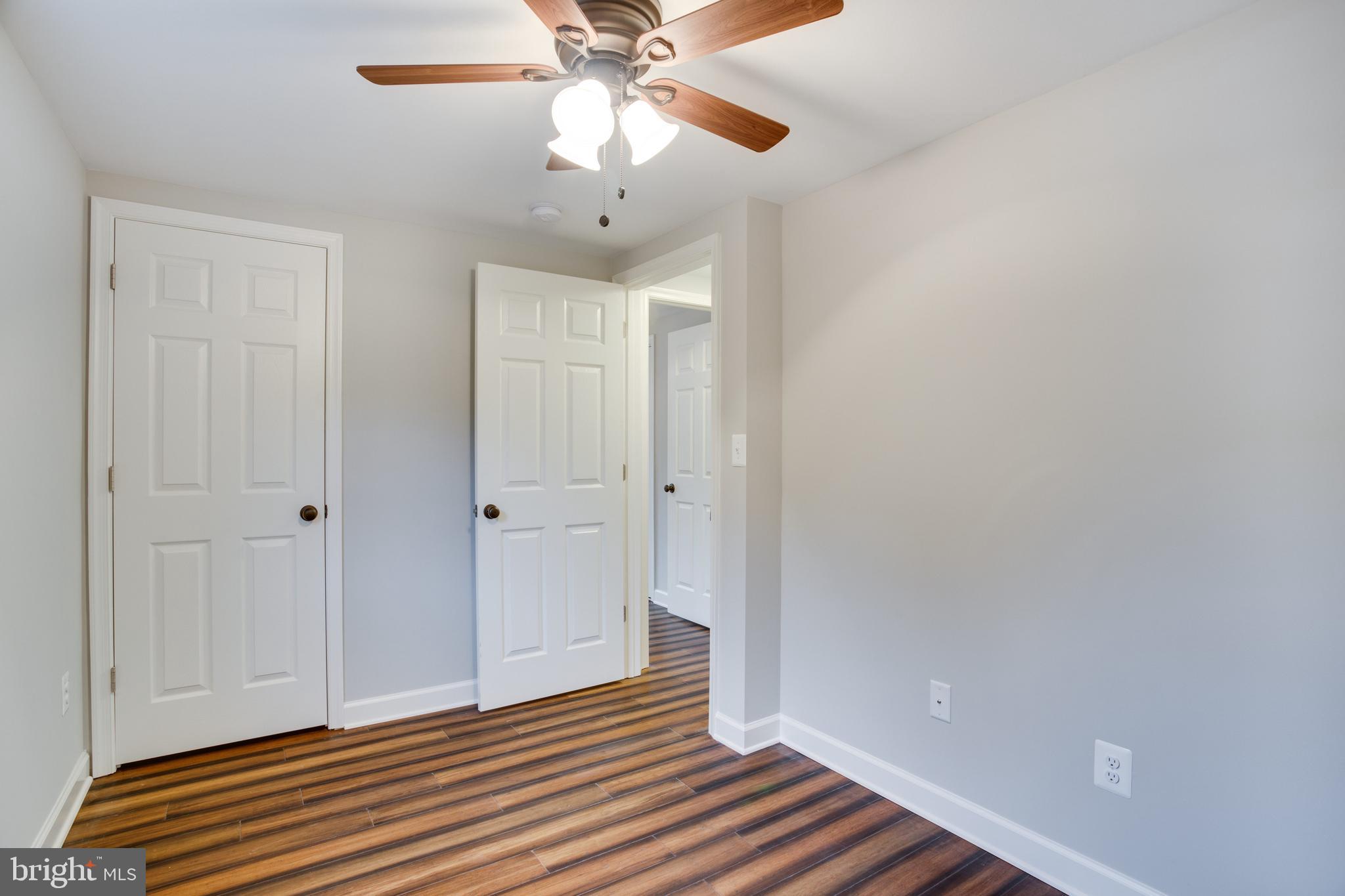 5601 Cherry Hill Road Huntingtown, MD 20639 - Photo 20 of 37 an empty room with wooden floor closet and fan