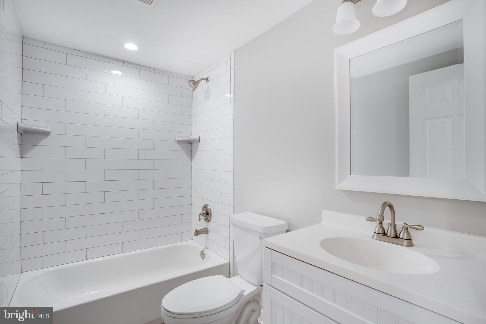 5601 Cherry Hill Road Huntingtown, MD 20639 - Photo 21 of 37 a bathroom with a bathtub shower sink vanity mirror and toilet