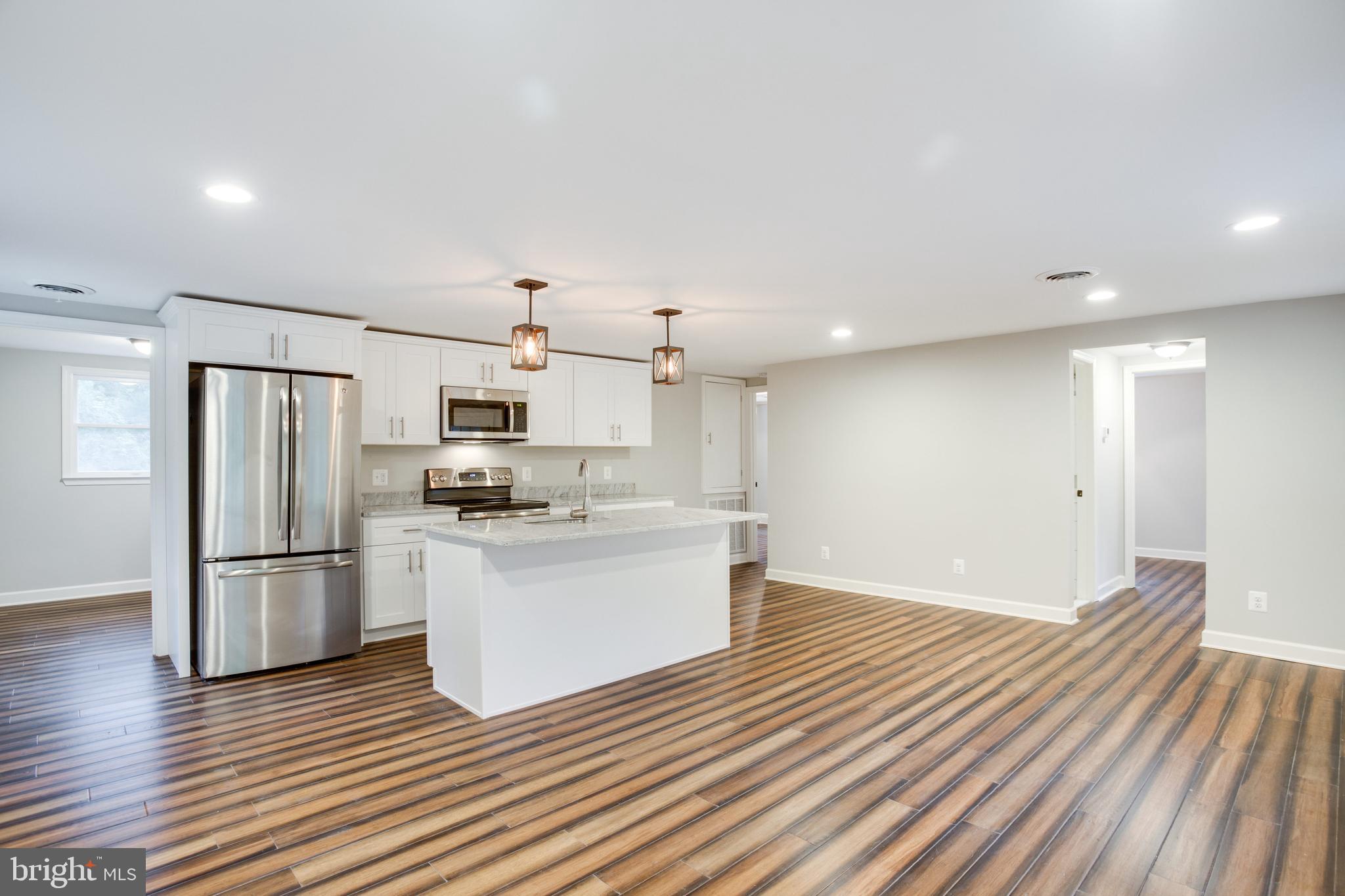 5601 Cherry Hill Road Huntingtown, MD 20639 - Photo 3 of 37 a kitchen with stainless steel appliances wooden floor and large windows