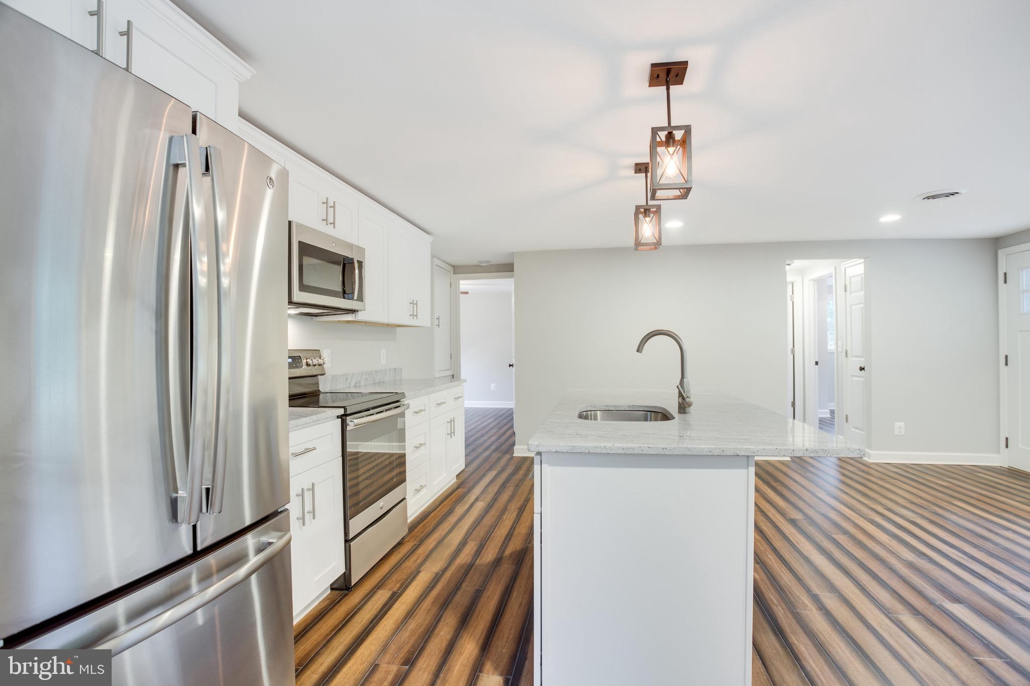 5601 Cherry Hill Road Huntingtown, MD 20639 - Photo 5 of 37 a kitchen with stainless steel appliances granite countertop a sink stove and refrigerator