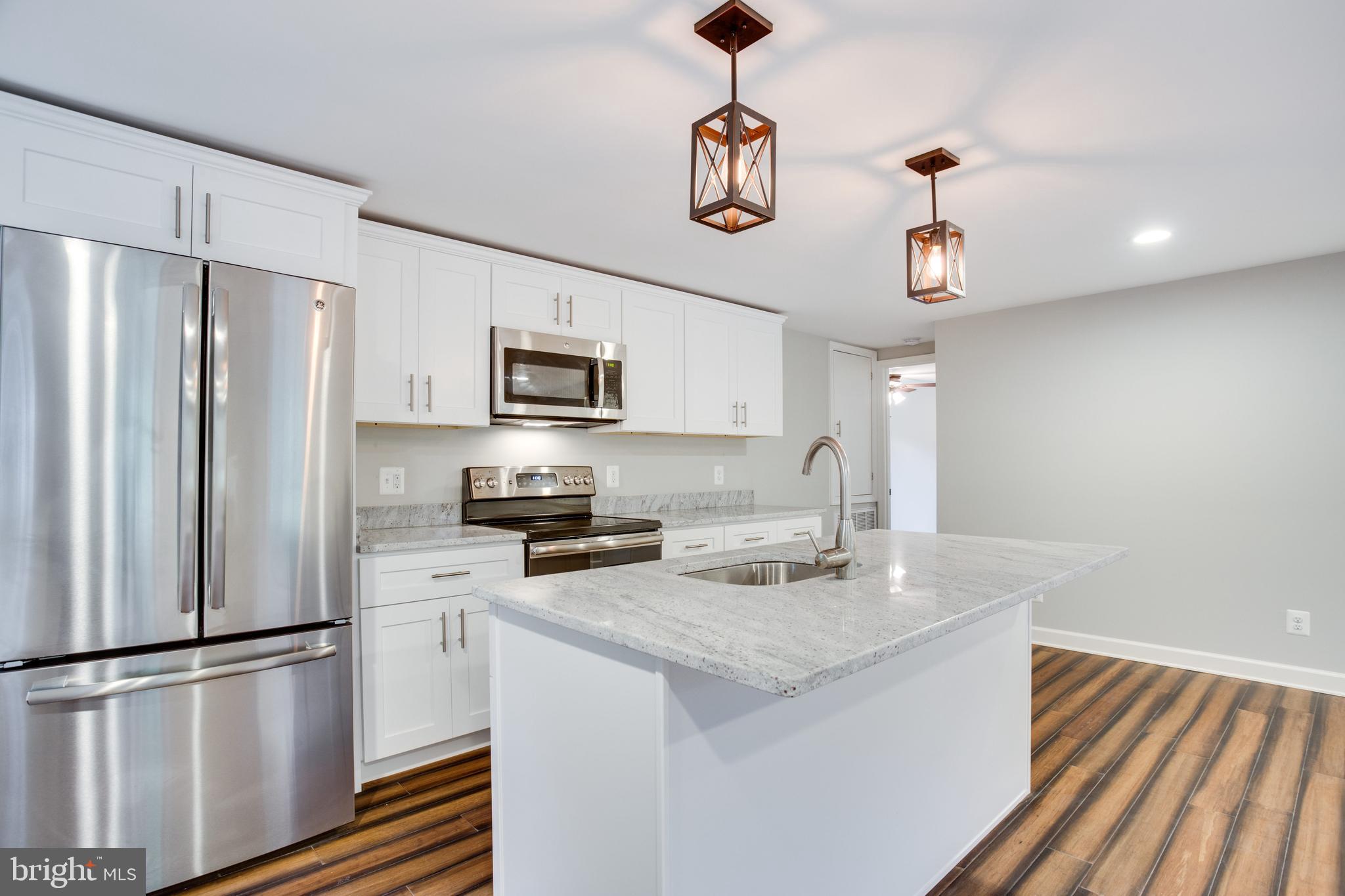 5601 Cherry Hill Road Huntingtown, MD 20639 - Photo 6 of 37 a kitchen with stainless steel appliances granite countertop a refrigerator a stove a sink dishwasher and a refrigerator with wooden floor