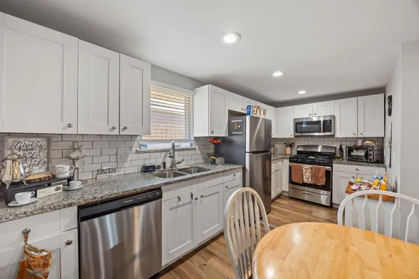 a kitchen with stainless steel appliances granite countertop a sink dishwasher stove top oven and refrigerator